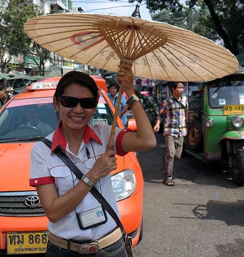 Tour guide Wilai standing on busy street in Chiang Mai.